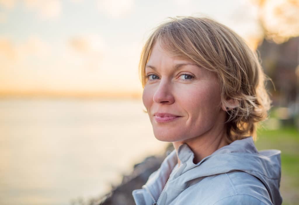 Mid 30's Woman with strong smile at sunset.